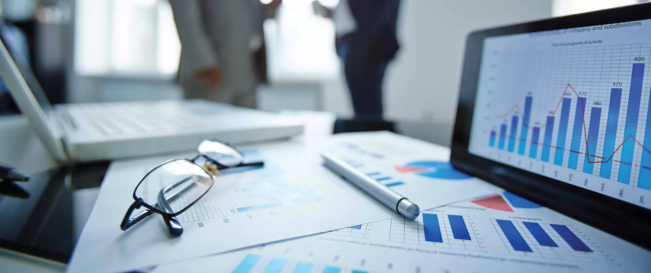 Consulente finanziario del Consorzio Veneto Garanzie durante una sessione di analisi strategica con imprenditore, documenti finanziari e grafici di pianificazione aziendale su tavolo professionale